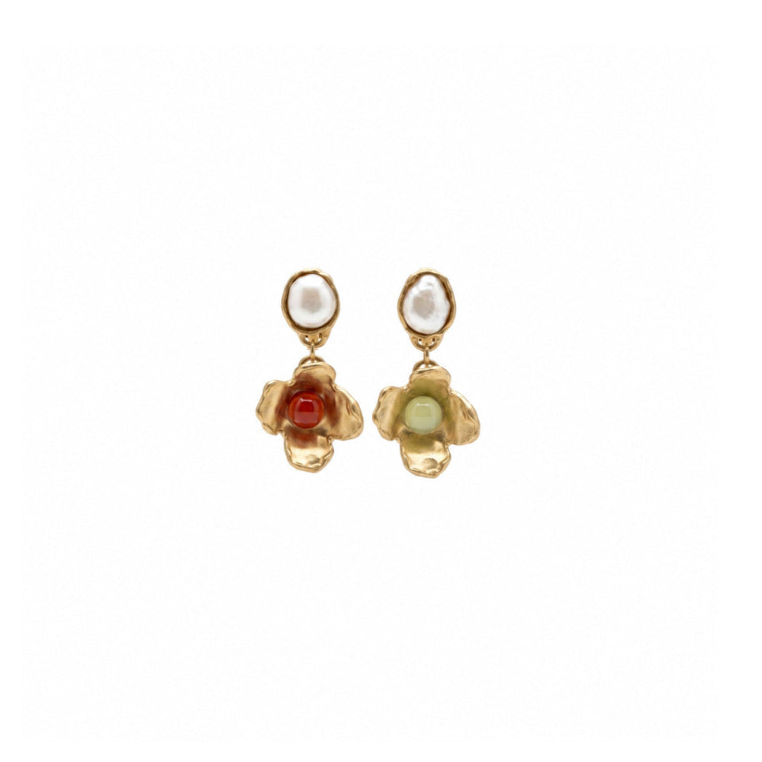 A pair of gold dangle earrings with white oval pearl studs and small flower charms featuring one red center and one pale green center, shown on a plain white background.