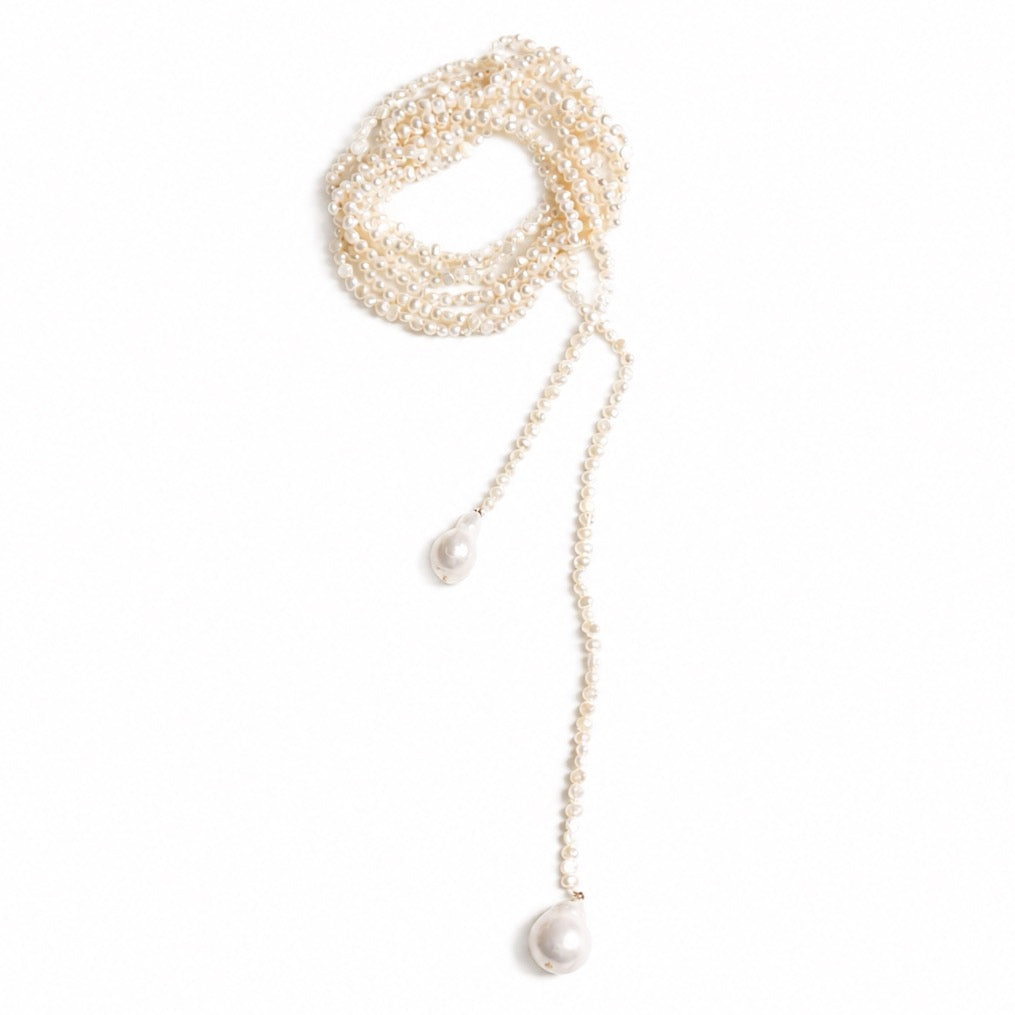 A very long pearl bead necklace with gold-tone chain links and two dangling larger baroque pearls, displayed on a clean white background.