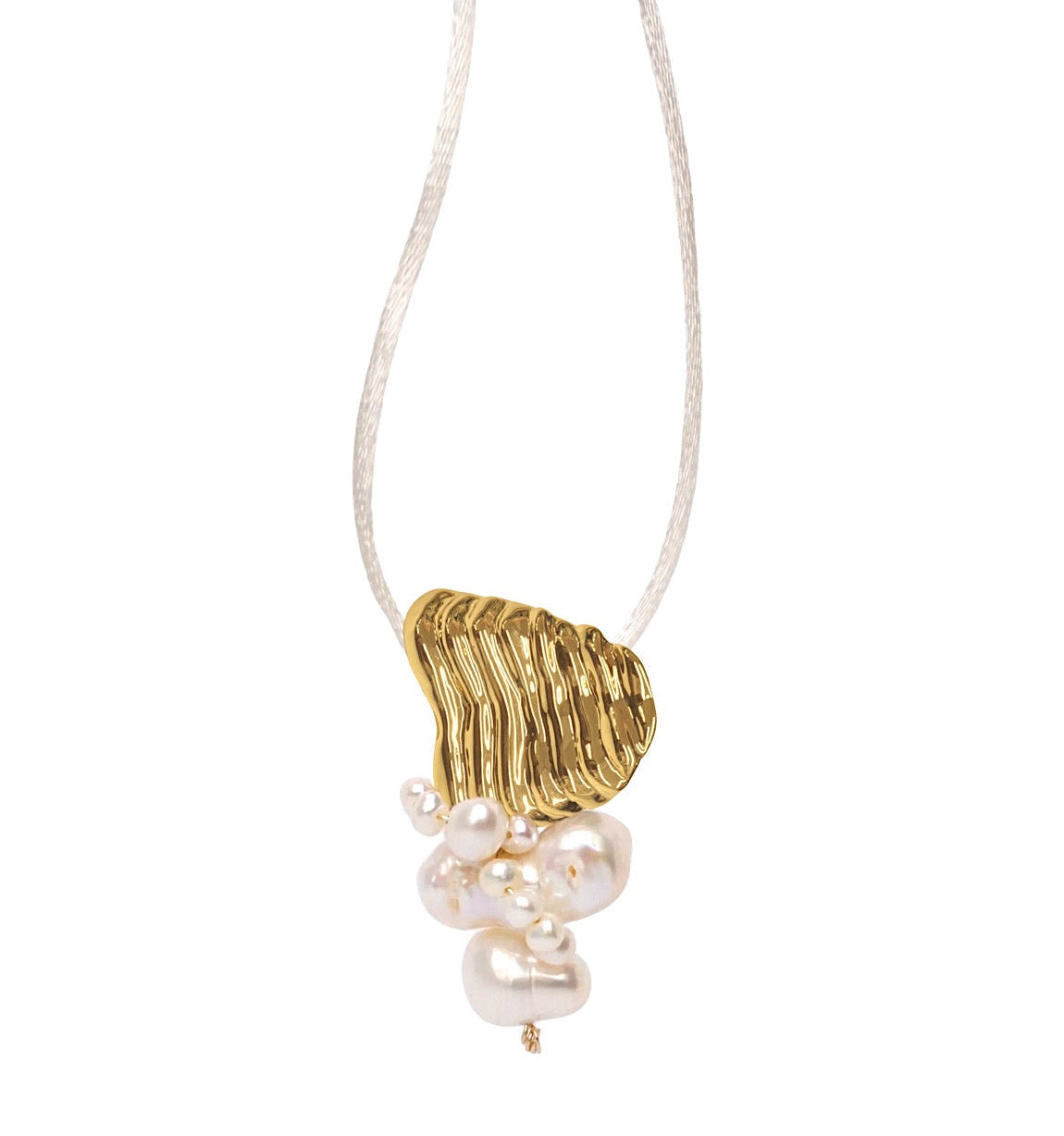 A gold pendant necklace featuring a textured golden charm with a cluster of white freshwater pearls hanging below, suspended on a thin white cord against a solid white background.