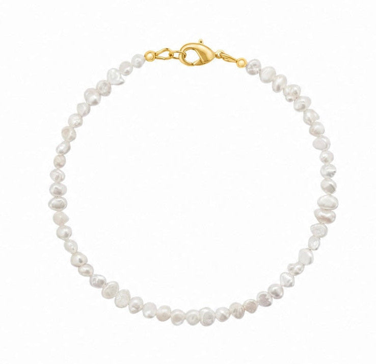 A delicate single-strand bracelet made of irregular white baroque pearls, finished with a polished gold lobster clasp, shown on a plain white background.