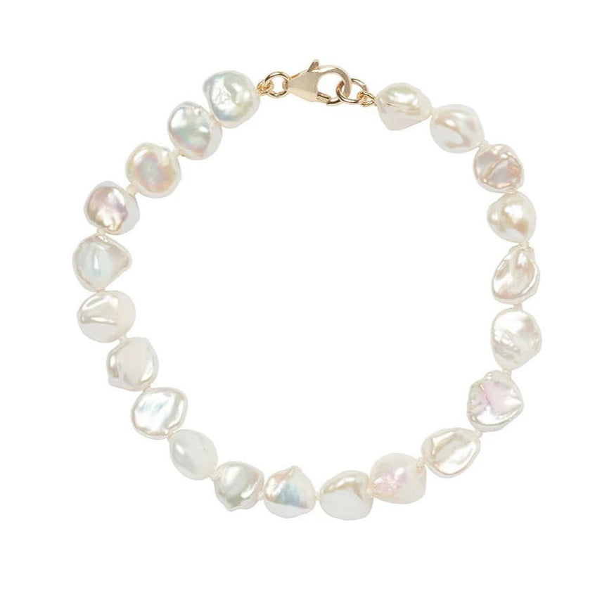 A delicate bracelet made of irregular, baroque-style white pearls with a gold clasp, displayed on a clean white background.