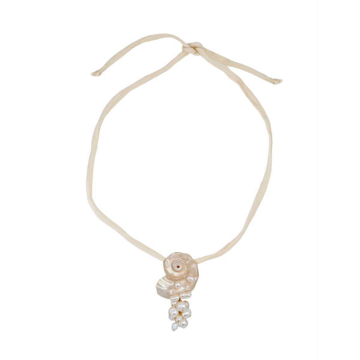 A delicate cream-colored cord necklace featuring a central shell charm and a small pearl cluster dangle, presented on a solid white background.