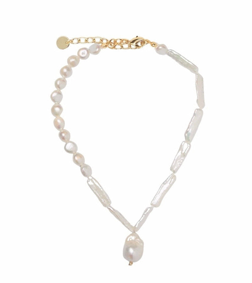 A delicate necklace featuring white baroque pearls and textured white rectangular beads, accented with a gold-tone clasp and extender chain on a solid white background.